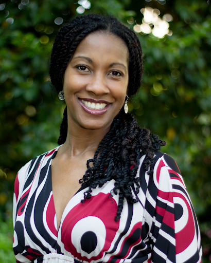 South Arts Joy Young in a red, white and black blouse in front of lush trees