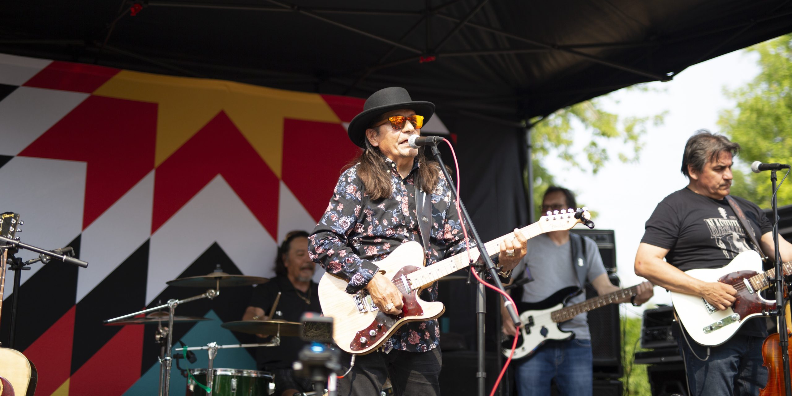 A picture of a band playing on stage for the public.