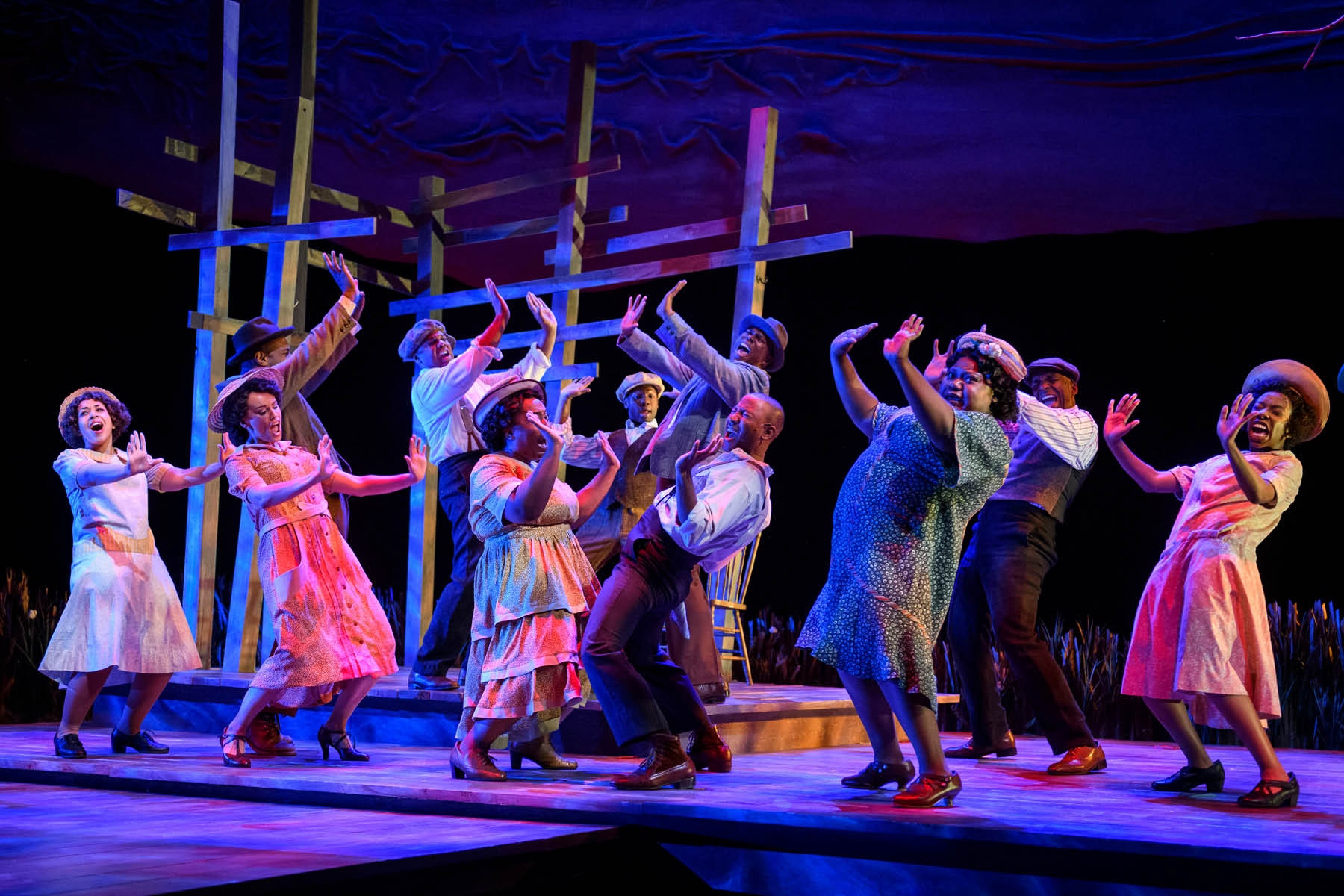 The Color Purple. A bunch of people dancing and singing on stage in the spotlight.