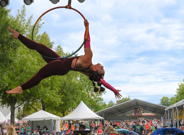 01RED_6428 A woman gymnast in the air performing outside in front of a crowd